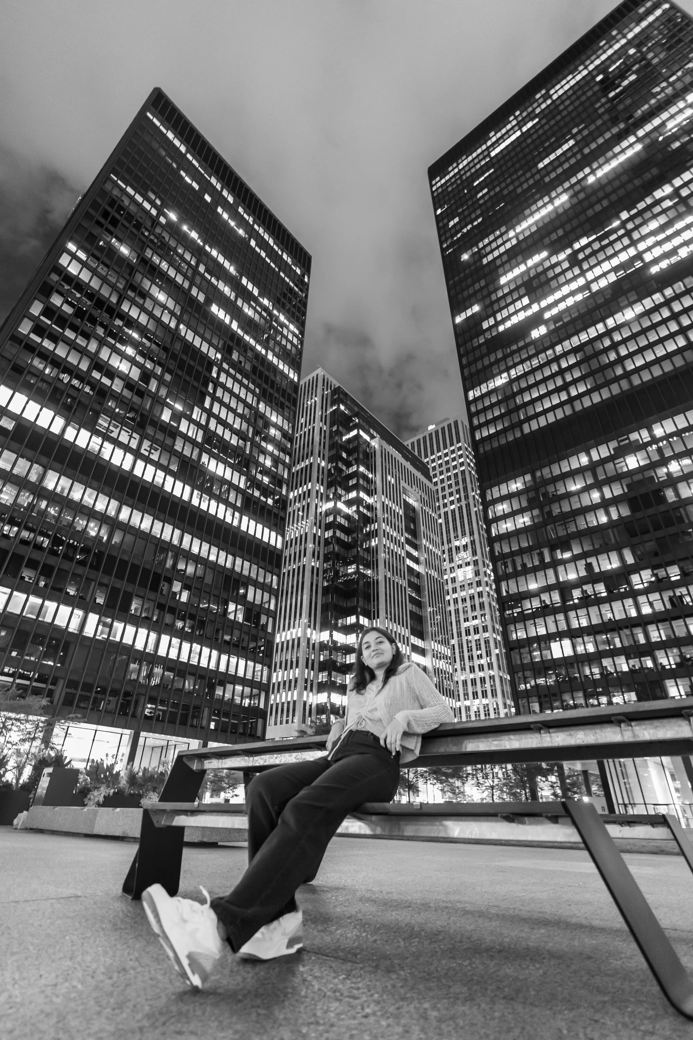 A figure mid-leap between two tower blocks, shot upward in black and white.