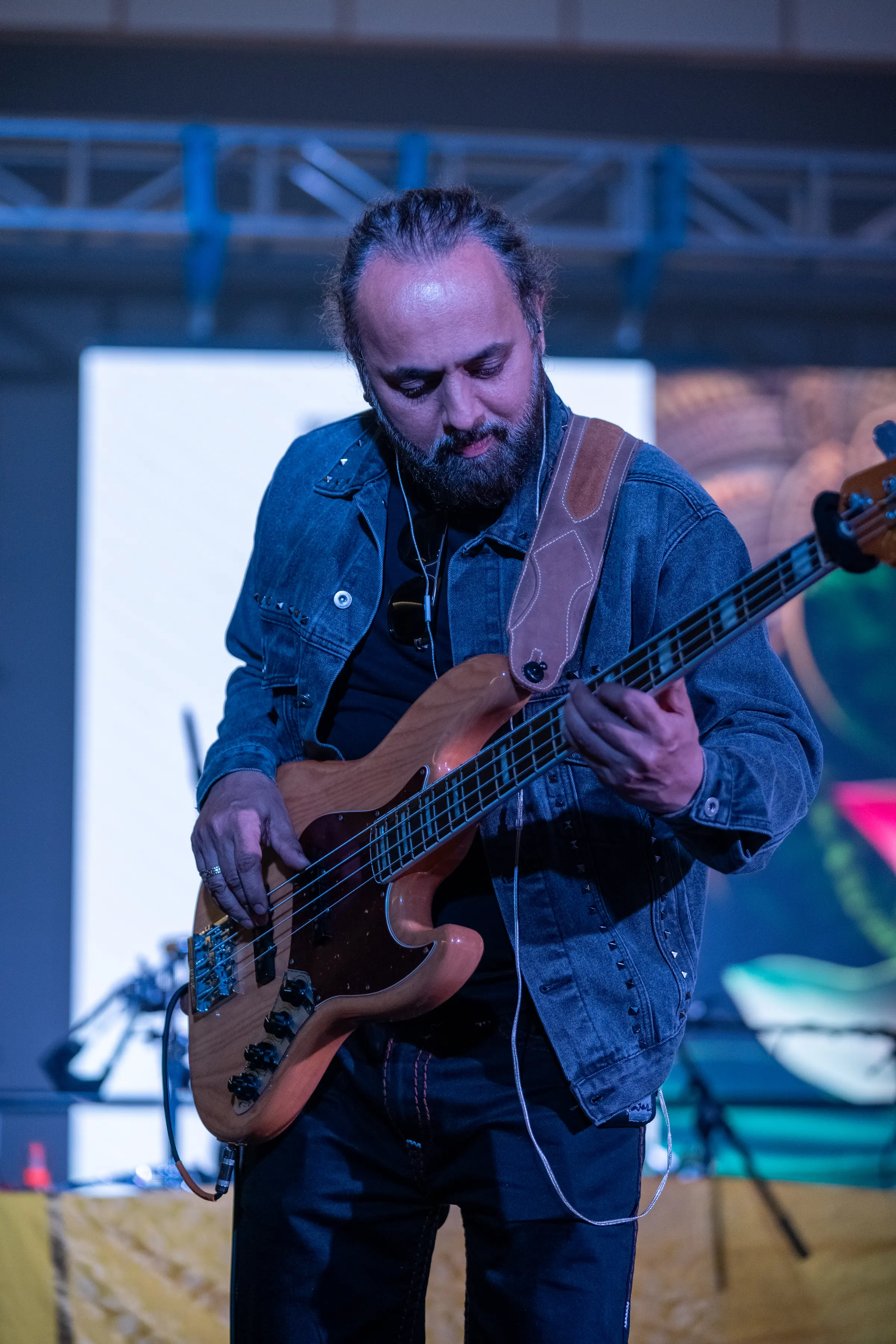 A bass player under the stage lights.