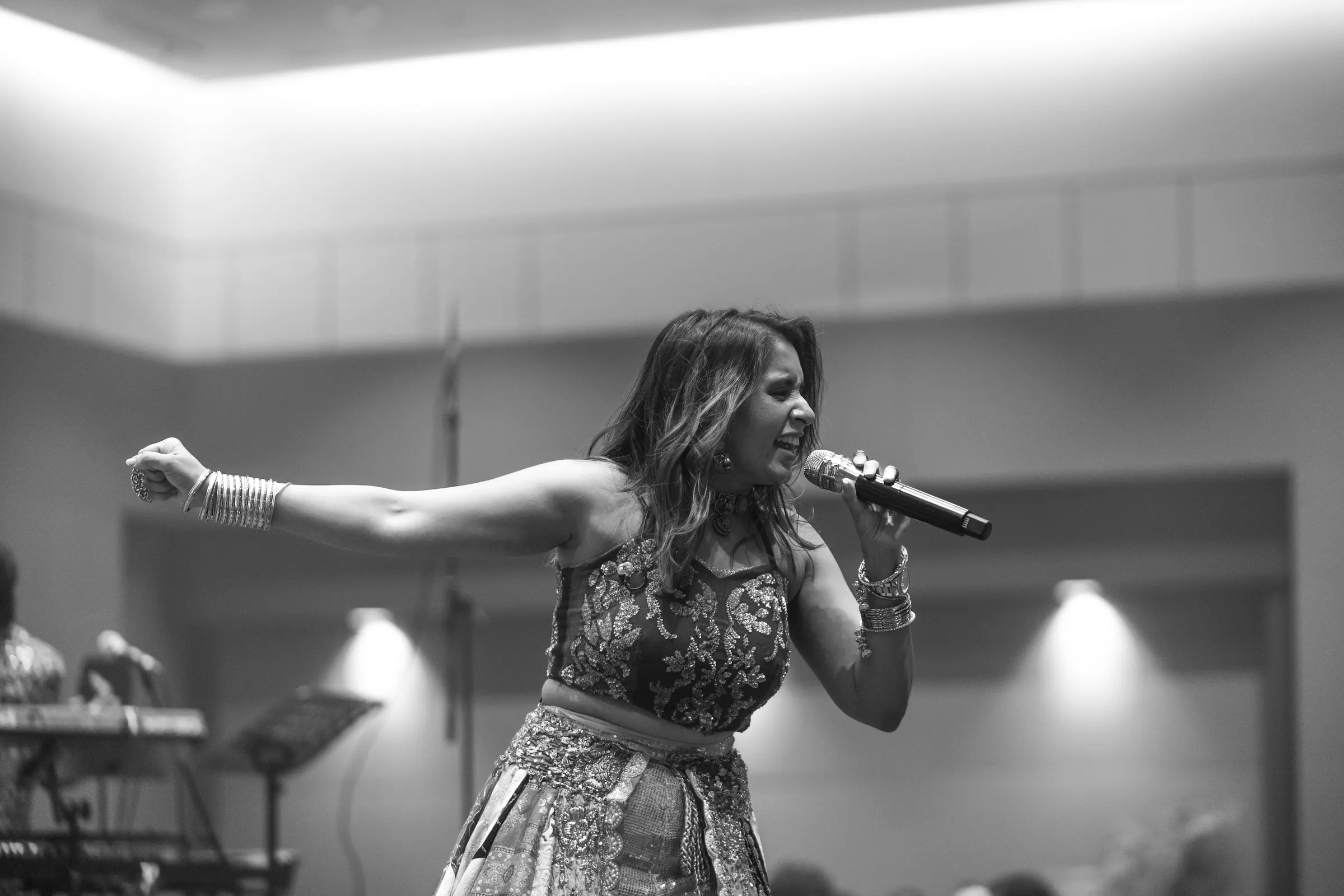 A singer with her arm outstretched to the room, black and white.